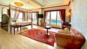A spacious room with a four-poster bed, a sitting area with a sofa, and a large window offering a view of the city. - Riviera Hotel Dubai (Dubai)