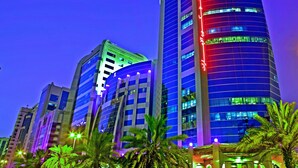 A modern high-rise building with illuminated signage and a curved facade. - Emirates Concorde Hotel & Suites (Dubai)