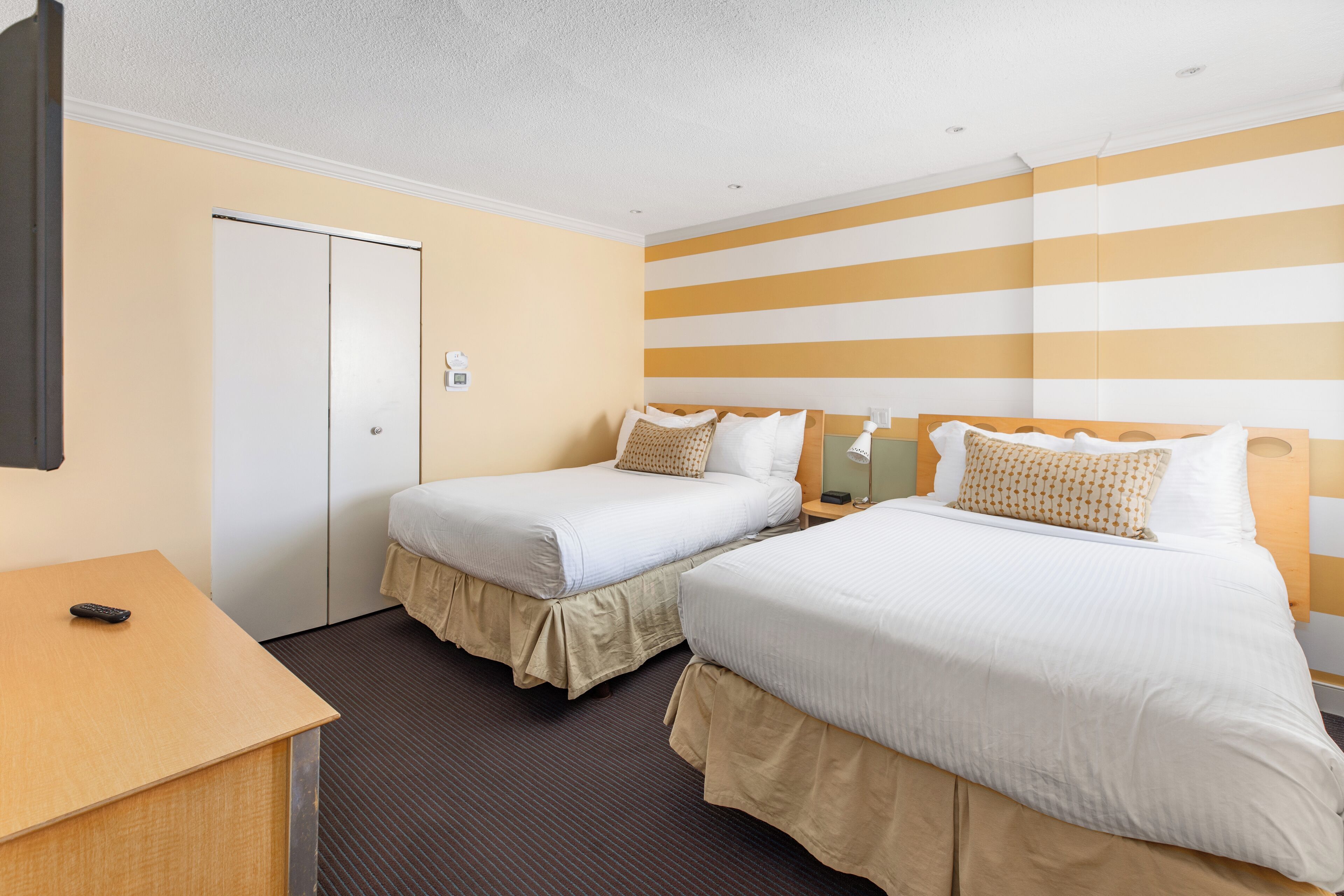 Une chambre d’hôtel avec deux lits, un bureau et une armoire.
