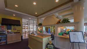 A restaurant interior with a counter, menu display, and seating area. - Oceanfront Pan American Hotel (Wildwood Crest)