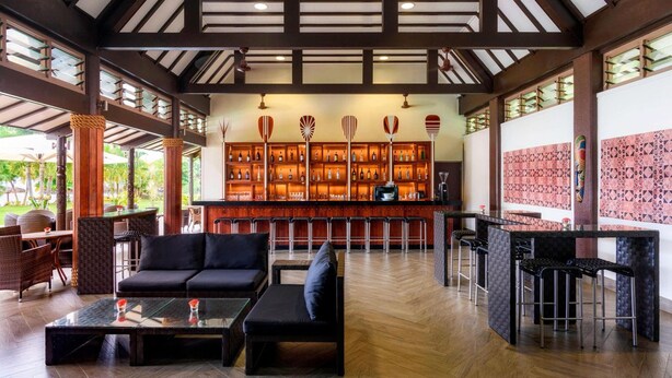 A spacious lobby with a bar area, seating arrangements, and a patterned wall. - Samoa Beach Resort (Mulifanua)
