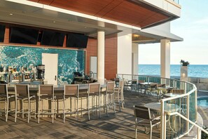A bar area with seating and a view of the sea. - Driftwood at the Boardwalk (Myrtle Beach)