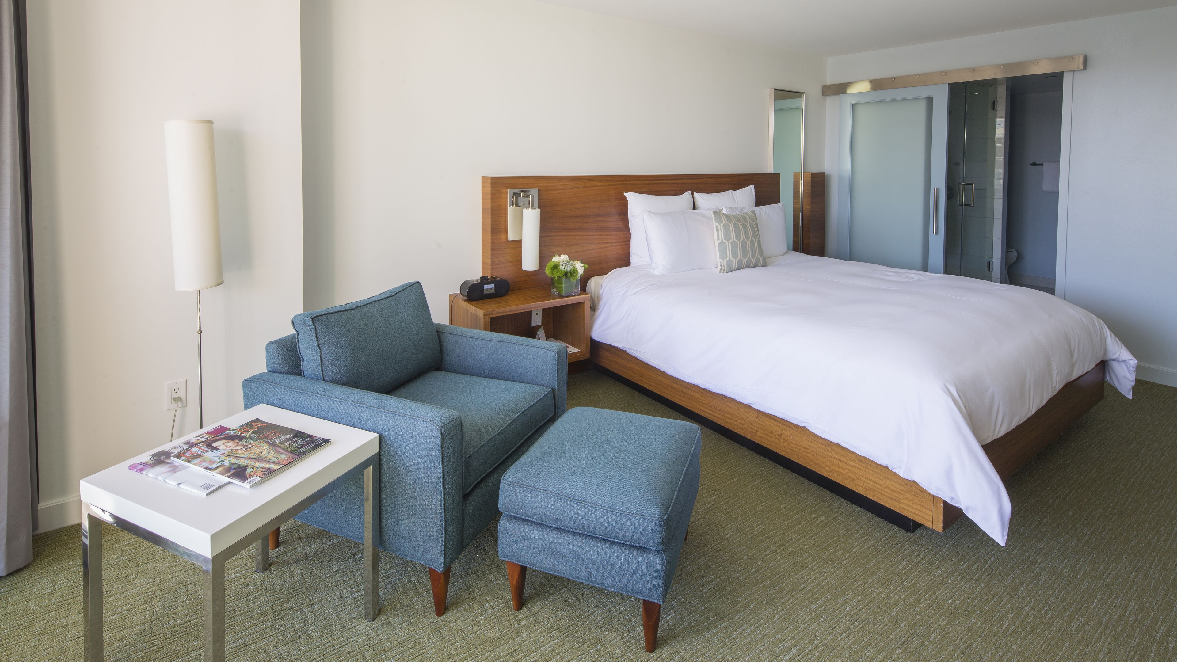 Una habitación de hotel con una cama, un escritorio, una silla y una mesita.
