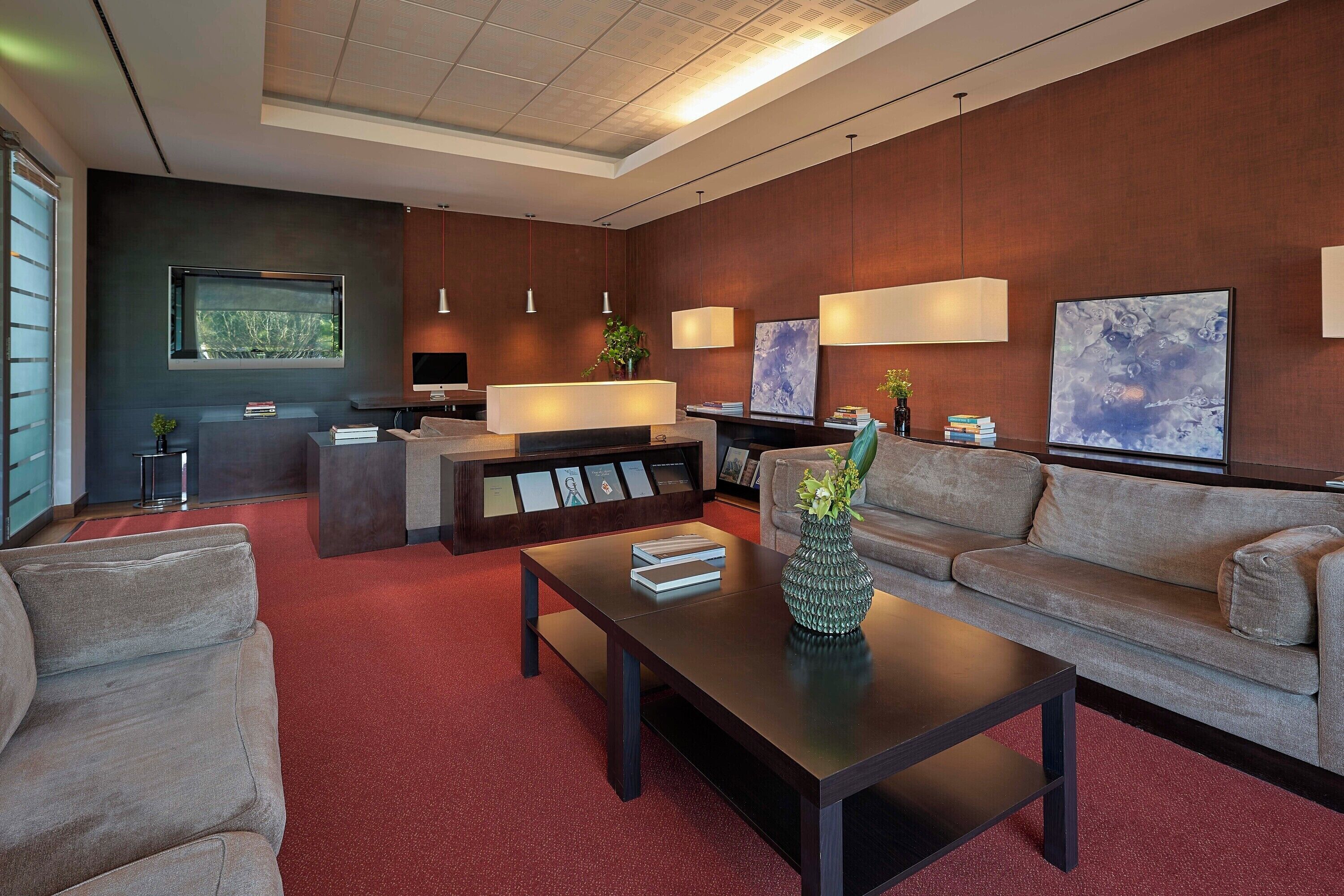 A modern living room with a sofa, a coffee table, a TV, and a desk area.