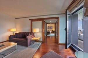 Suite – deluxe, byutsikt | Oppholdsområde | Flatskjerm-TV og filmkjøp