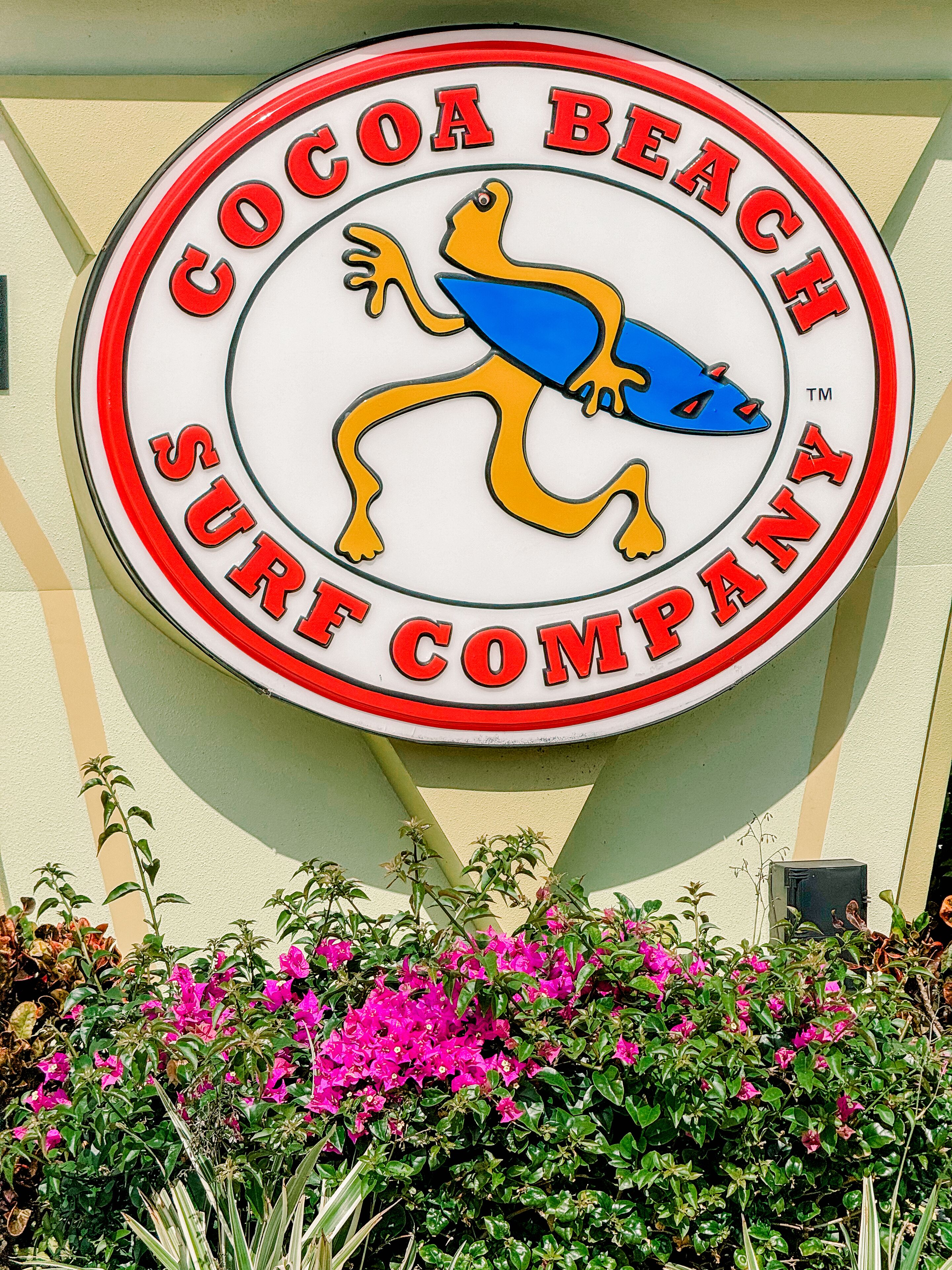A circular sign with a logo and text for Cocoa Beach Surf Company.