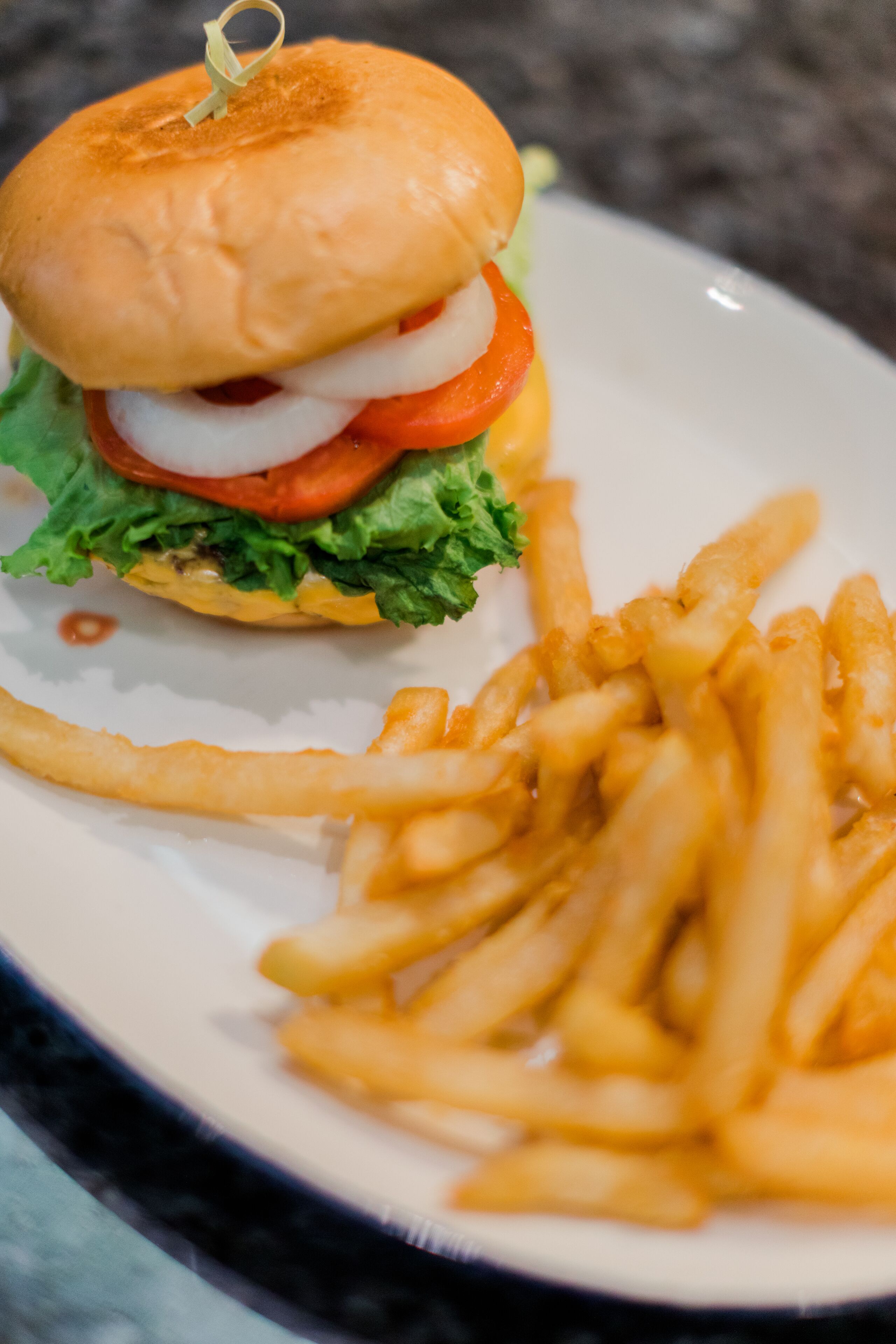 Un plato con una hamburguesa y papas fritas.