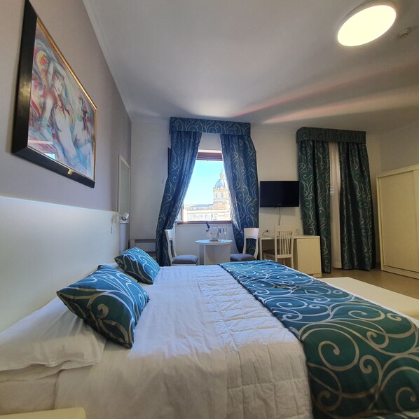 A bedroom with a bed, a desk, a chair, and a TV. - Hotel Centrale Spa & Relax (Alcamo)