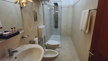 A bathroom with a sink, toilet, and shower.