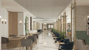 Un hall d’hôtel moderne avec un long couloir, des espaces de détente et un comptoir d’accueil.