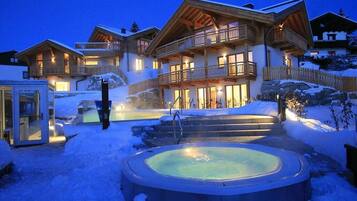 Een binnenzwembad, een buitenzwembad, ligstoelen bij het zwembad