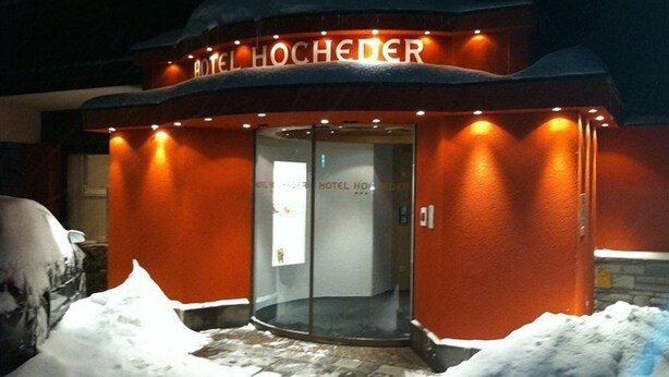 En hotellentrédörr med en glasdörr och upplyst skyltning.