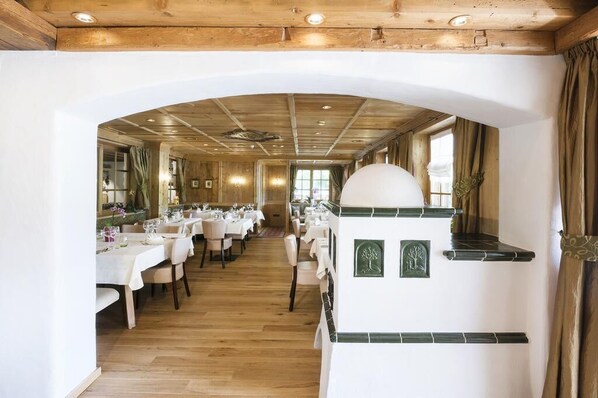 Un restaurant doté d’une grande salle à manger, d’un plafond en bois et de murs blancs.