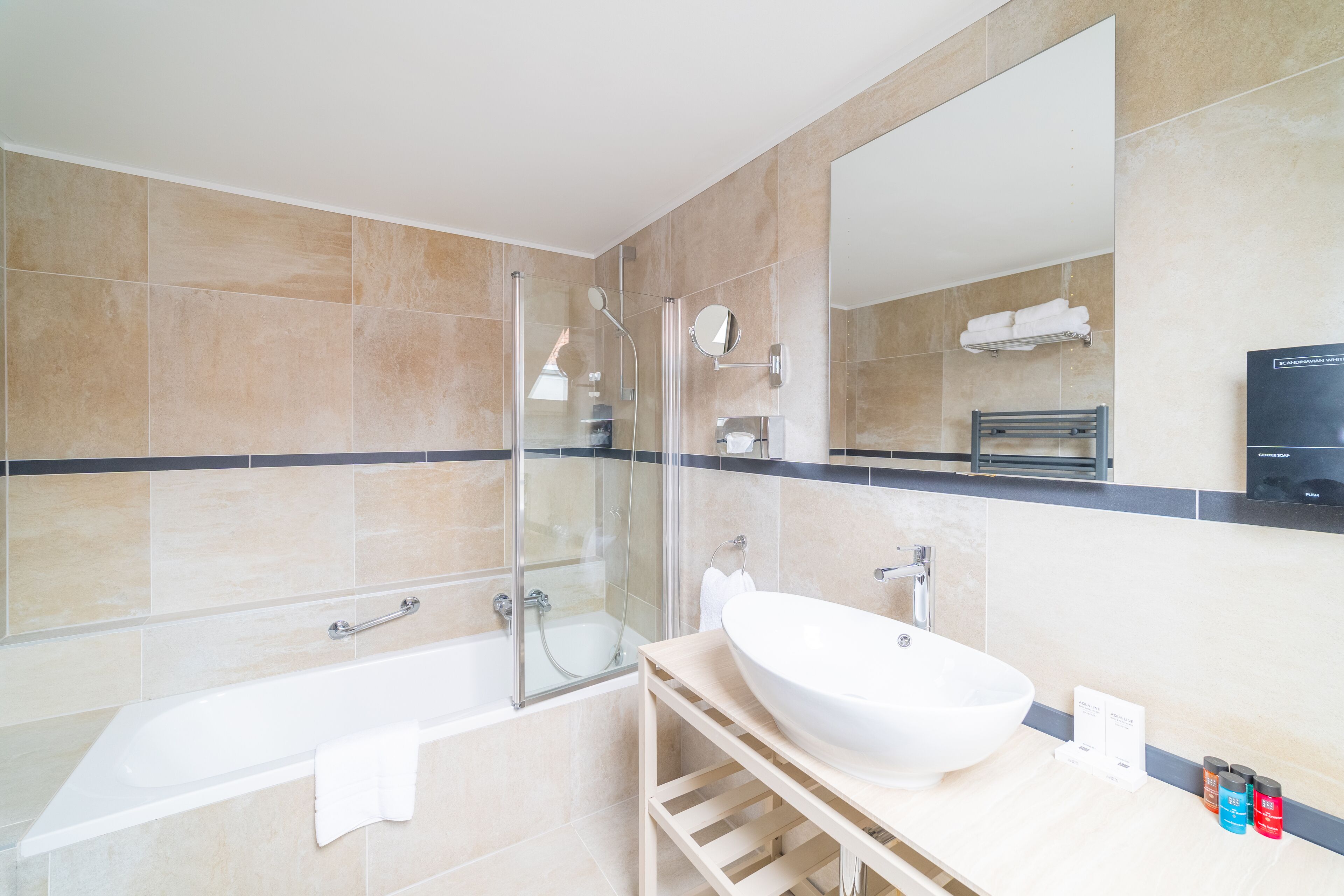 Une salle de bain moderne avec une douche à parois de verre, une baignoire sur pieds et un grand lavabo blanc.