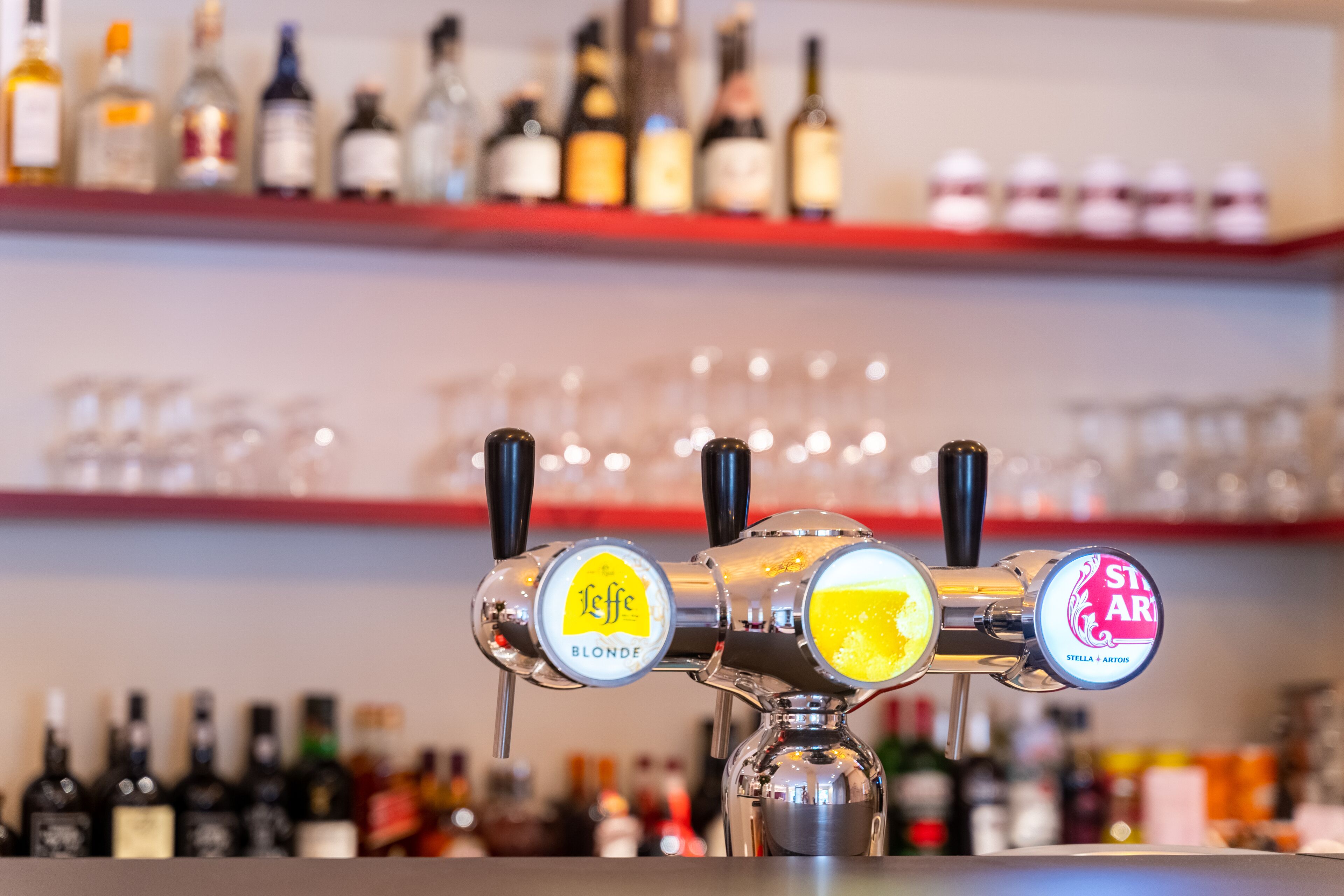 Een bar met drie tappunten, gelabeld 'Leffe Blonde', 'Stella Artois' en 'Stella Artois'.