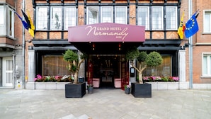 Fachada del Grand Hotel Normandy con una entrada destacada, puertas dobles y un cartel luminoso.
