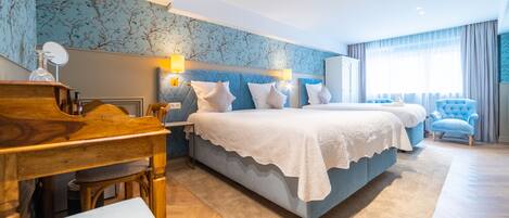 A modern hotel room with a large bed, a desk, and a chair.