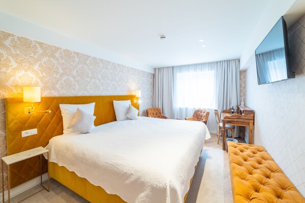 A hotel room with a large bed, a desk, a TV, and a bench. - Grand Hotel Normandy by CW Hotel Collection (Bruges)