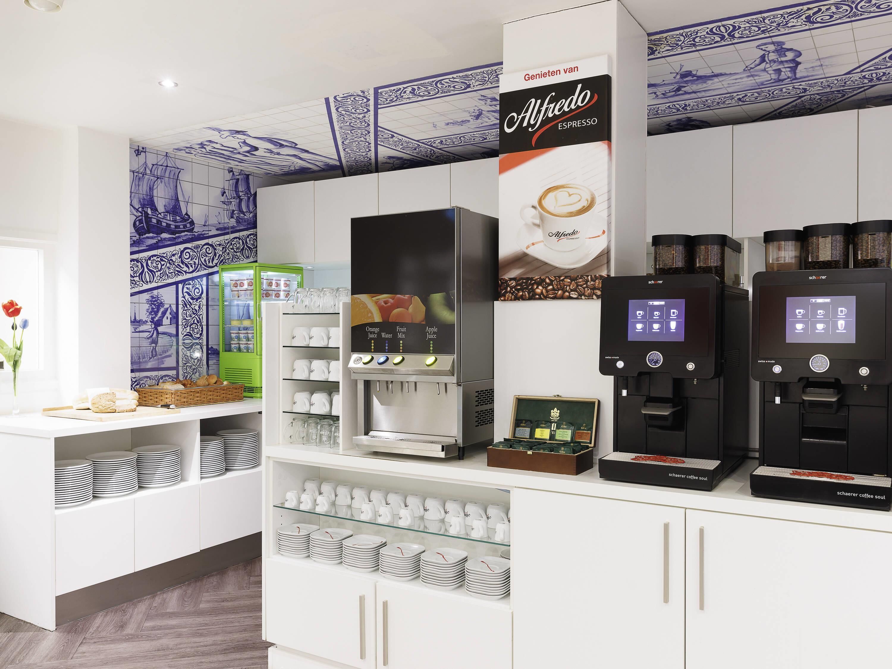 Un espace dédié au café, équipé de plusieurs machines à expresso, d’un assortiment de grains de café et d’une variété de tasses et de soucoupes.