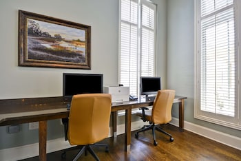 A conference room with long tables, chairs, and large windows. at Hampton Inn & Suites Charleston Airport