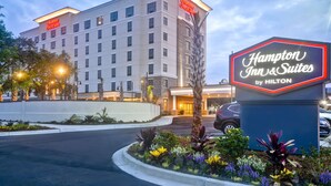 A Hampton Inn & Suites by Hilton building with a sign, surrounded by landscaped gardens and a parking area. - Hampton Inn & Suites Charleston Airport (North Charleston)