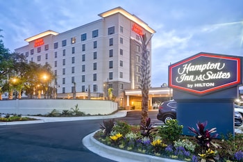 A courtyard with a fire pit, outdoor seating, and a building entrance in the background. at Hampton Inn & Suites Charleston Airport