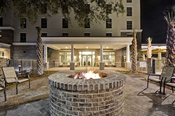 A conference room with round tables, chairs, and chandeliers. at Hampton Inn & Suites Charleston Airport