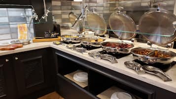 A buffet setup with various food items and utensils.