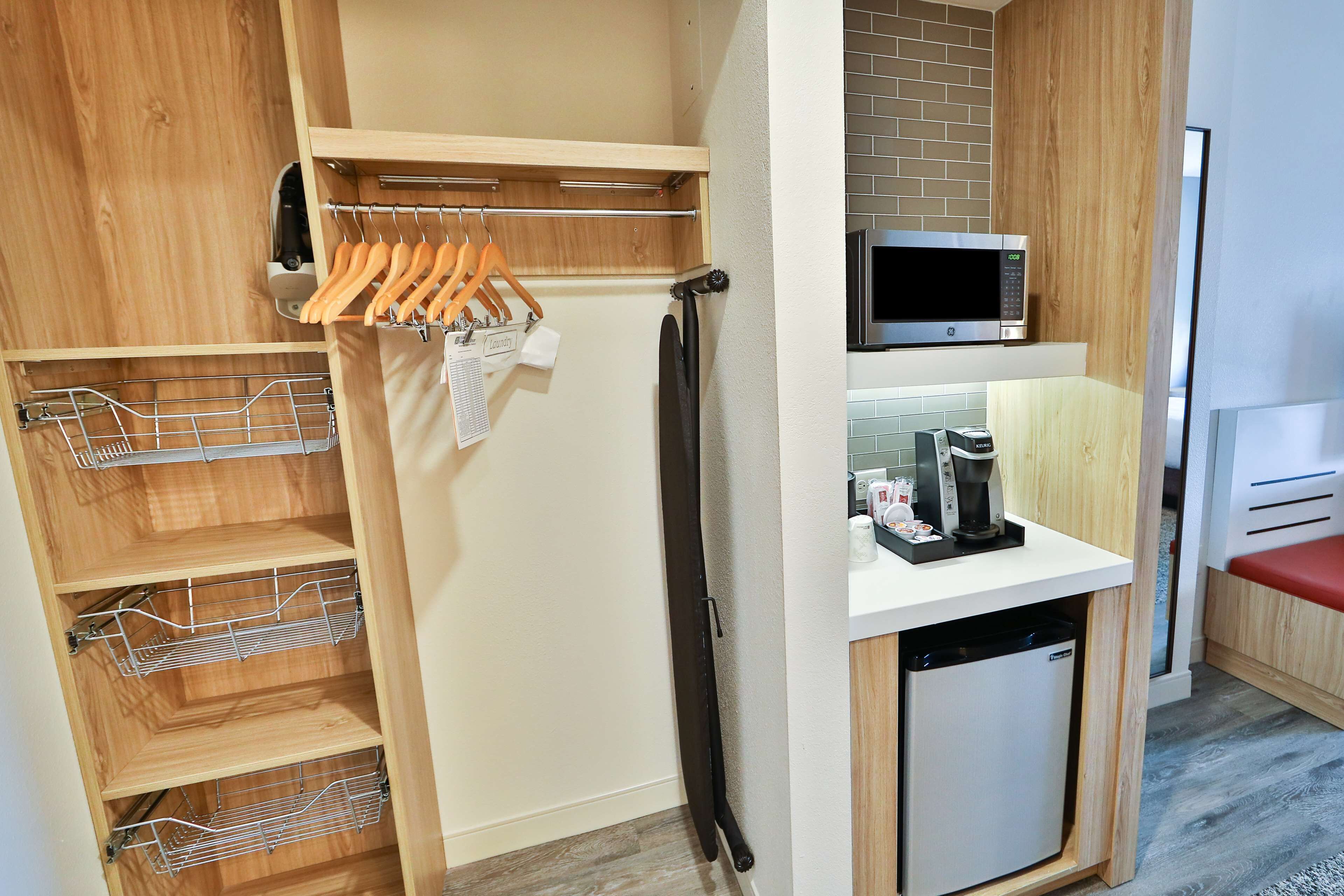 A compact kitchen with a microwave, coffee maker, and a small refrigerator.