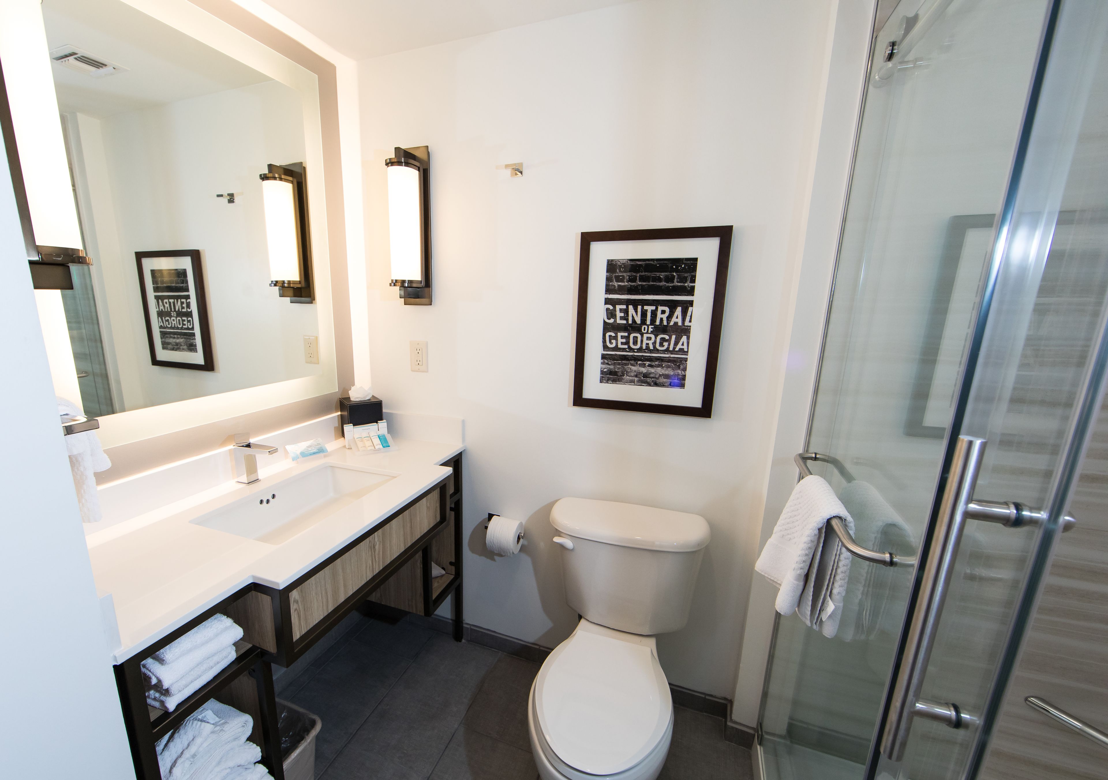 Ein modernes Badezimmer mit Waschbecken, Toilette und Duschkabine aus Glas.