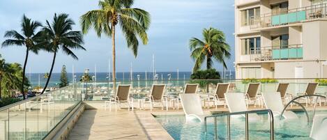 Una piscina al aire libre, tumbonas