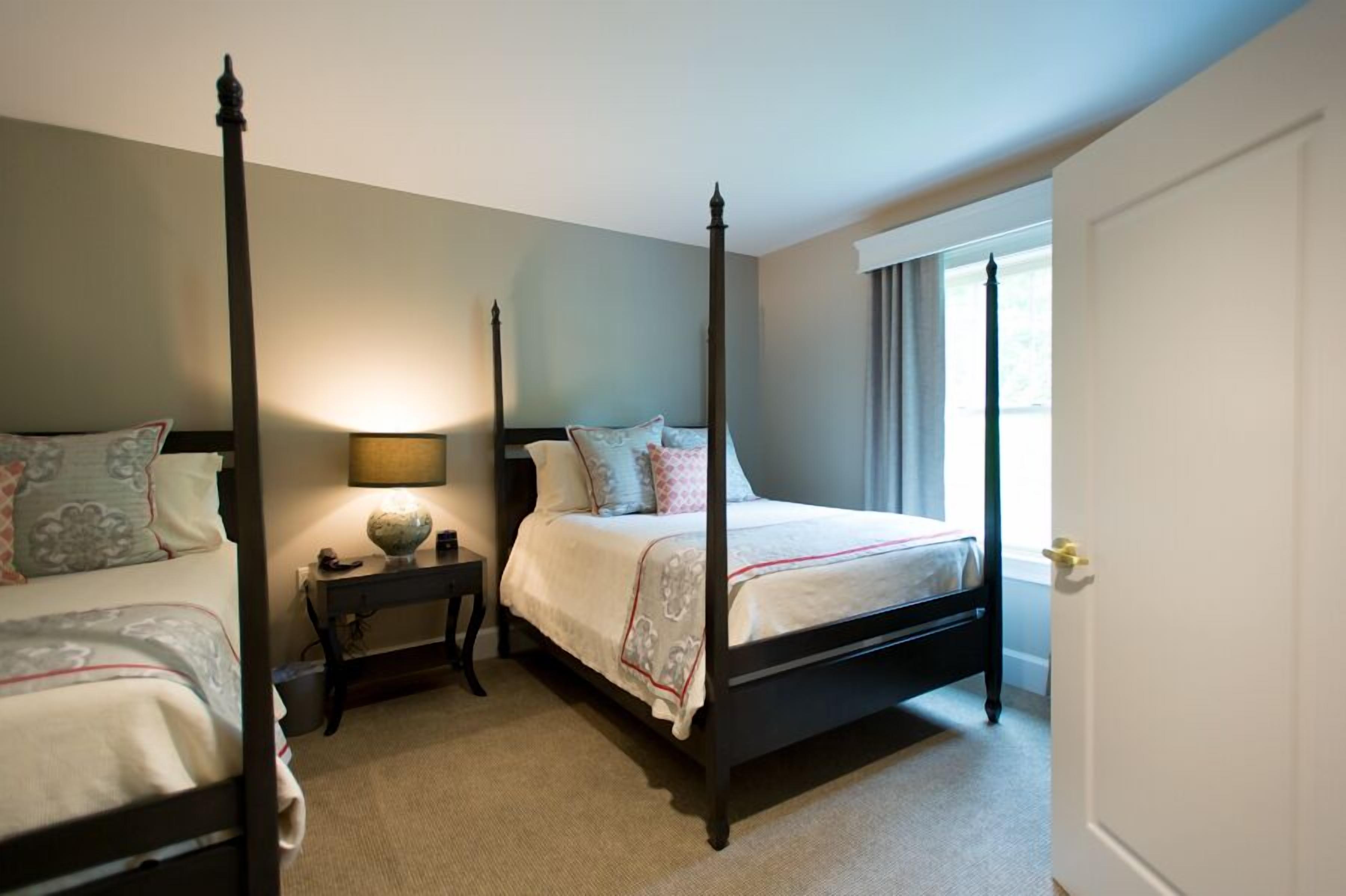 A four-poster bed with a nightstand, a lamp, and a globe on the nightstand.