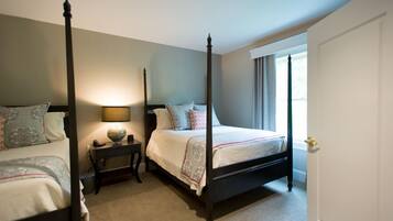 A four-poster bed with a nightstand, a lamp, and a globe on the nightstand.