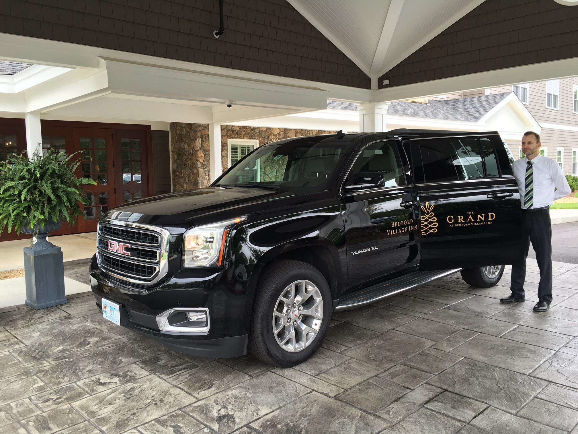 Un SUV GMC Yukon XL negro estacionado en Bedford Village Inn.