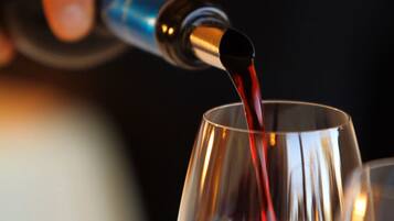 A metallic cup being filled with a red liquid.