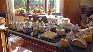 A cheese board with various types of cheese, each labeled with their names. - Hotel Empordà (Figueres)