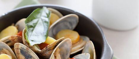 A bowl of clams with vegetables.