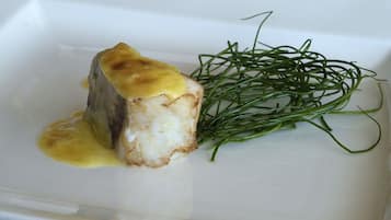 Un plato con salsa dorada y guarnición verde.