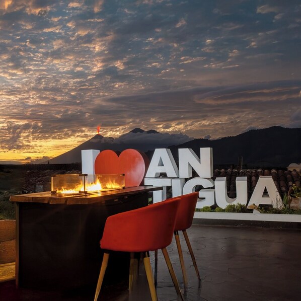 Un restaurante con vistas a un volcán y un cartel que dice "I LOVE GUAYA".