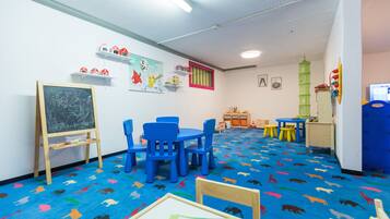 A classroom with blue chairs, a chalkboard, and educational decorations.