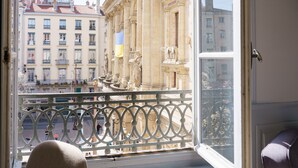A room with a large window overlooking a historic building with ornate architecture. - Hotel du Theatre (Lyon)