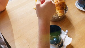 A dining table with bread, croissants, and a glass of orange juice. - Hotel du Theatre (Lyon)