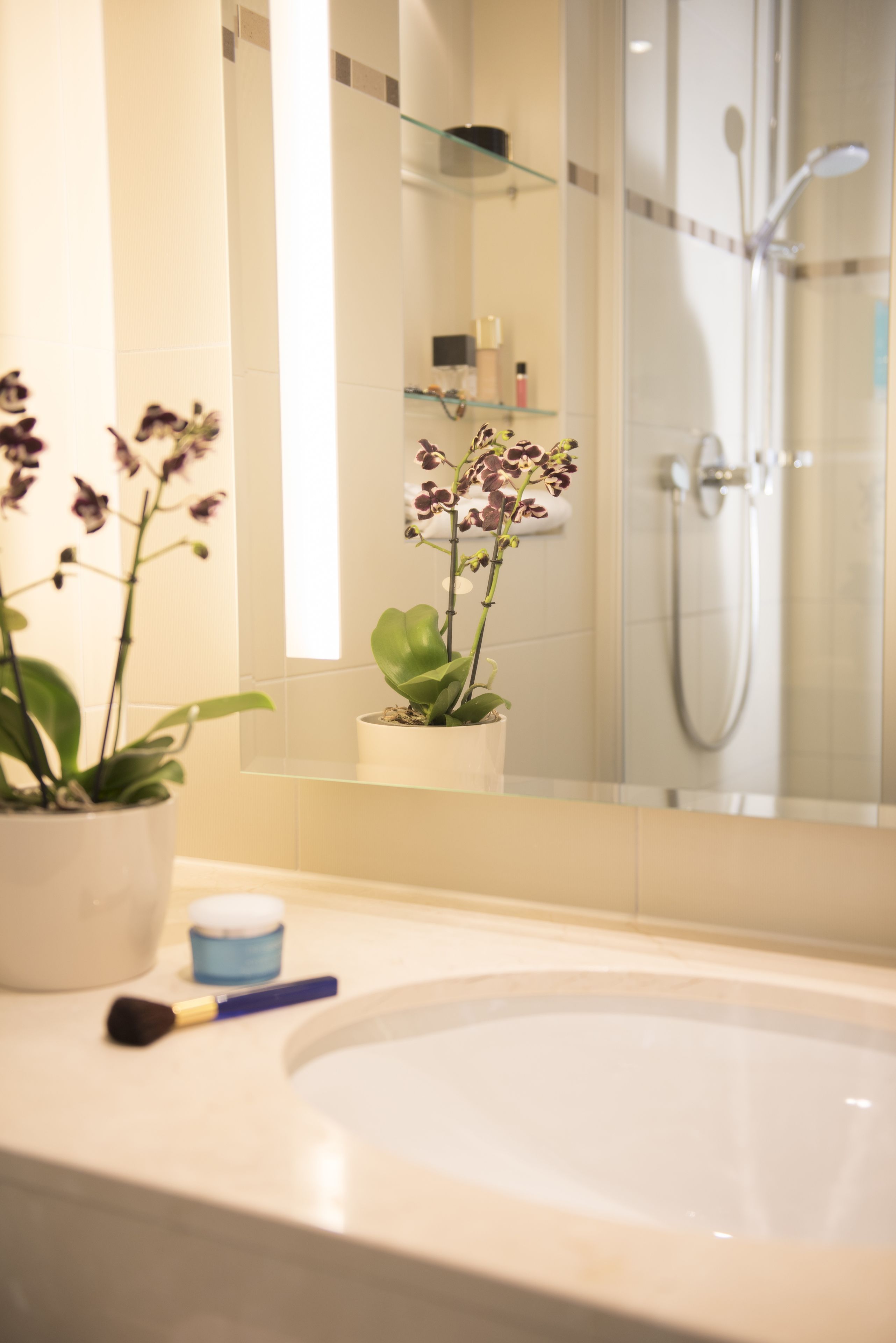 A bathroom with a bathtub, a sink, and a mirror reflecting a shower area.