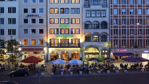 A hotel with multiple floors, outdoor seating, and various dining establishments. - Hotel Schlicker (Munich)