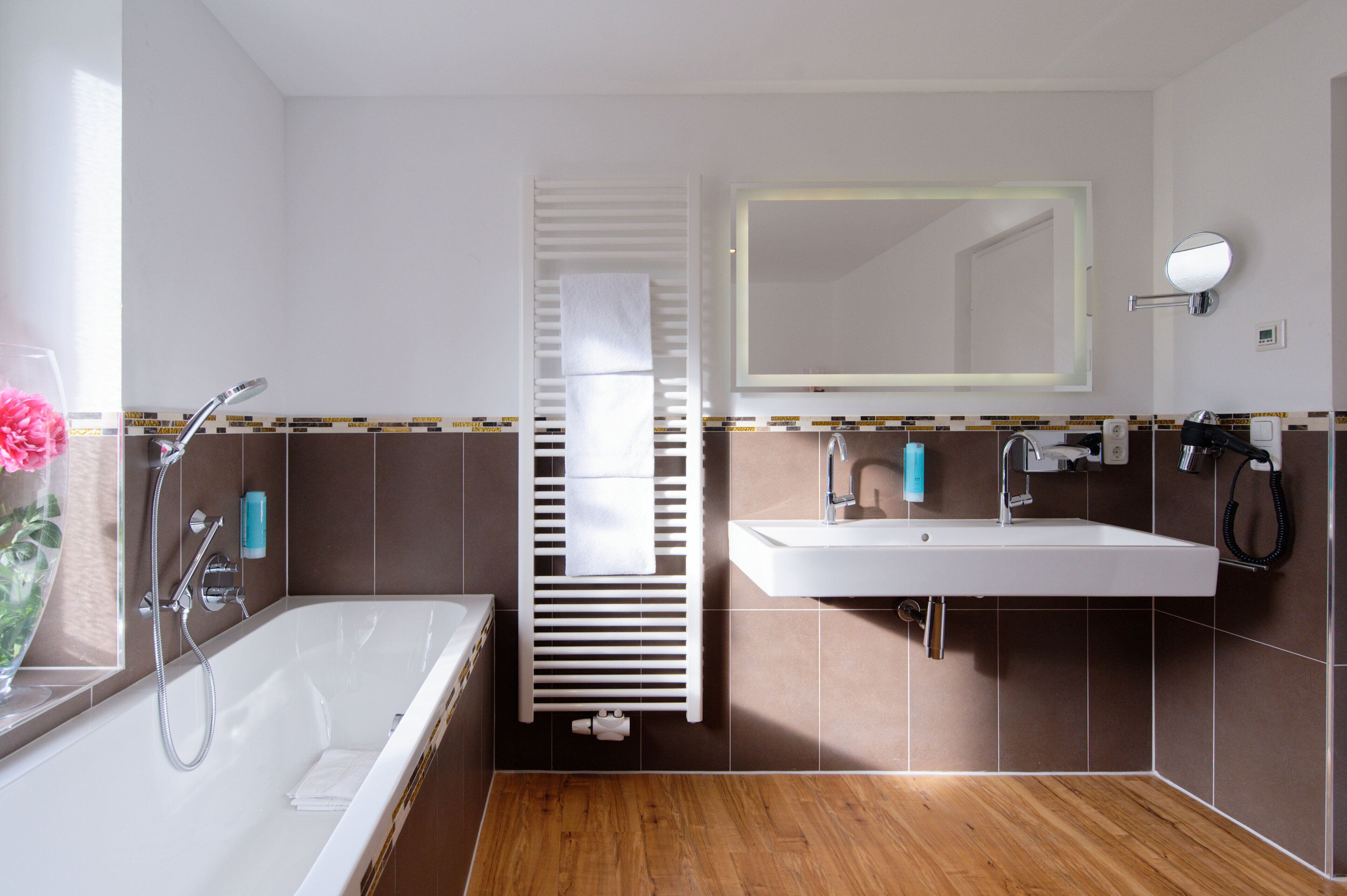 Un baño moderno con bañera, lavamanos y espejo.
