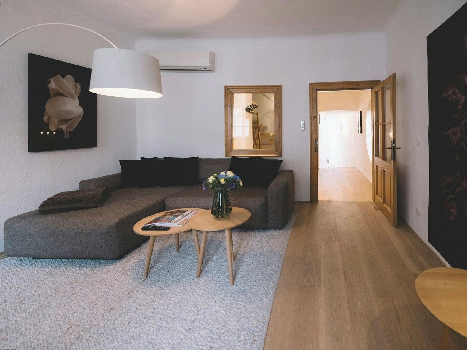 A modern living room with a grey sectional sofa, a round coffee table, and a large floor lamp.