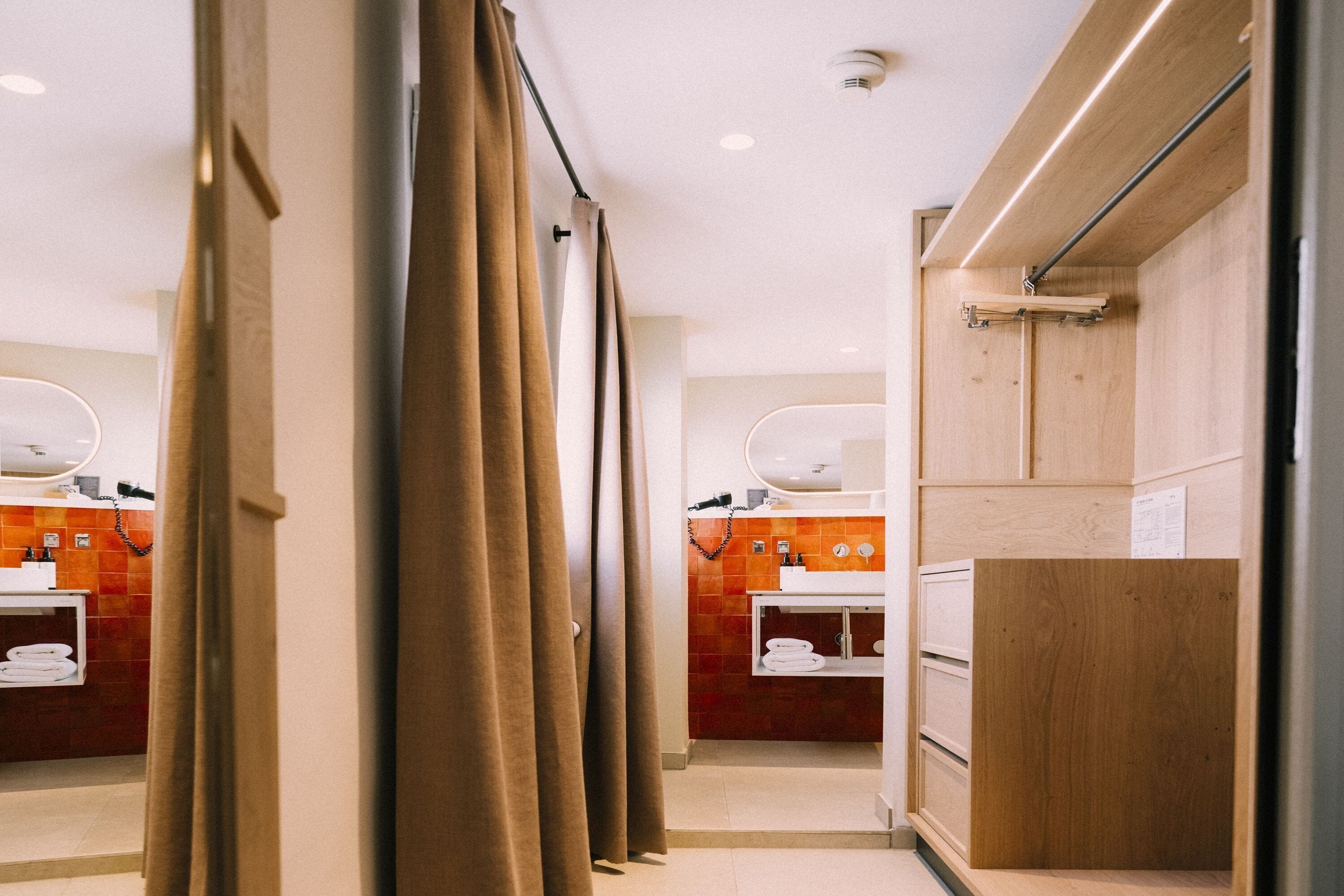 Une salle de bain moderne avec des meubles en bois, un lavabo blanc et un miroir.