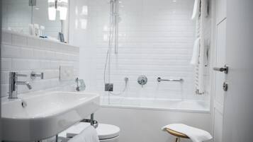 A modern bathroom with a white sink, toilet, and bathtub.