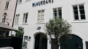 Un edificio con el nombre "Blauegans" en la fachada, con varias ventanas y una puerta.