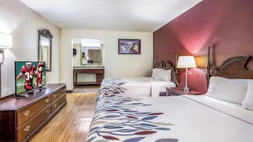 Une chambre d’hôtel avec un grand lit, une commode, une télévision, un miroir, une table de chevet avec une lampe et un tableau au mur.